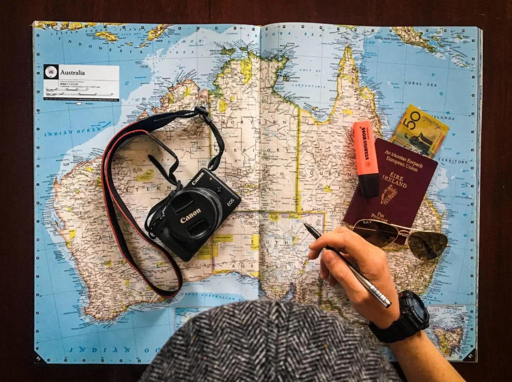 man looking at travel map with camera